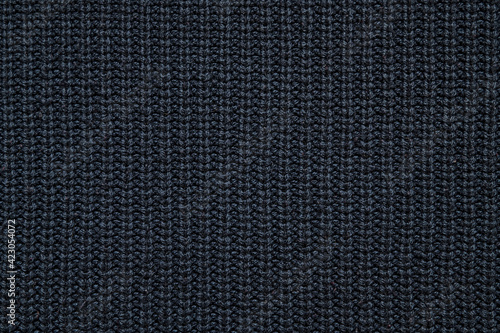 Fotografie abstract background of black knit fabric texture close up
