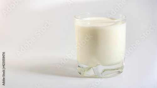 Glass of plant organic milk with shadow on white background