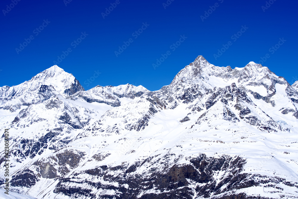 Snow capped mountains, snowfields and glaciers at Zermatt, Switzerland, seen from Gornergrat railway station. Photo taken March 23rd, 2021.