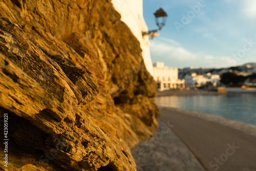 Marvelous sunrise at beautiful costal town Cadaques at Catalonia, Spain. Cosy houses on the Mediterranean sea light by the warm rising sun with cliff. Serenity and off season vacation. 