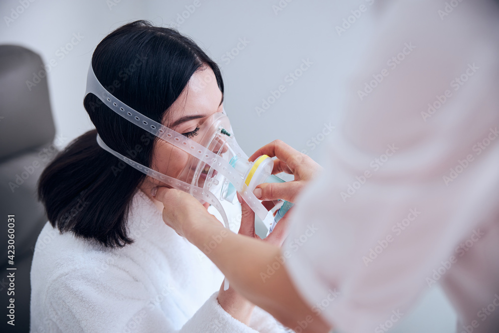 Joyous dark-haired lady undergoing a medical procedure