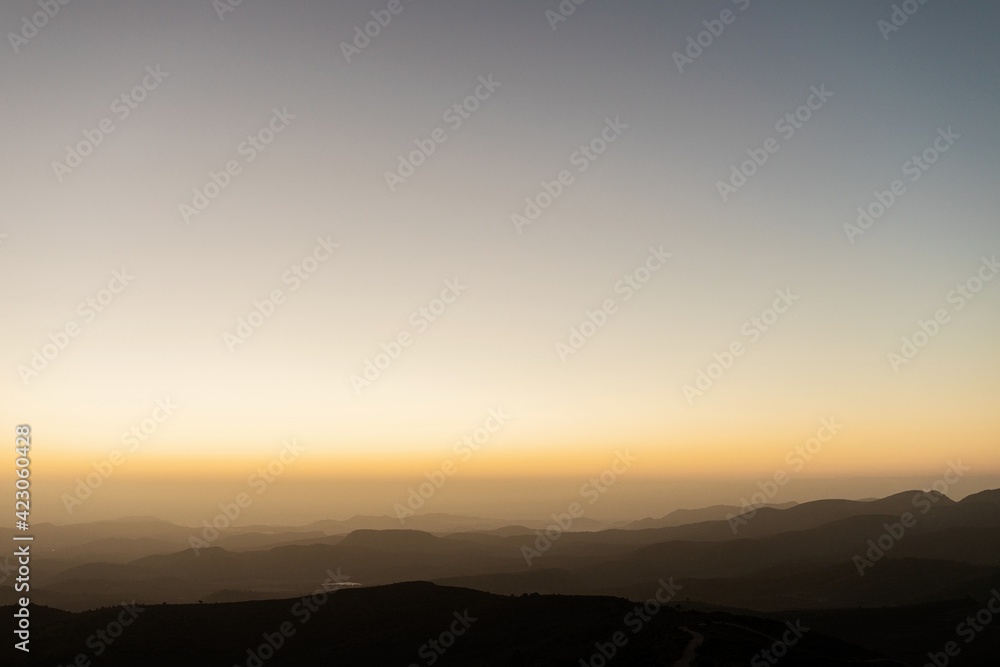 Sunset over mountain range on background of cloudless sky in the evening Sunset over mountain range on background of cloudless sky in the evening