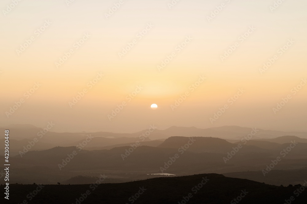 Sunset over mountain range on background of cloudless sky in the evening Sunset over mountain range on background of cloudless sky in the evening