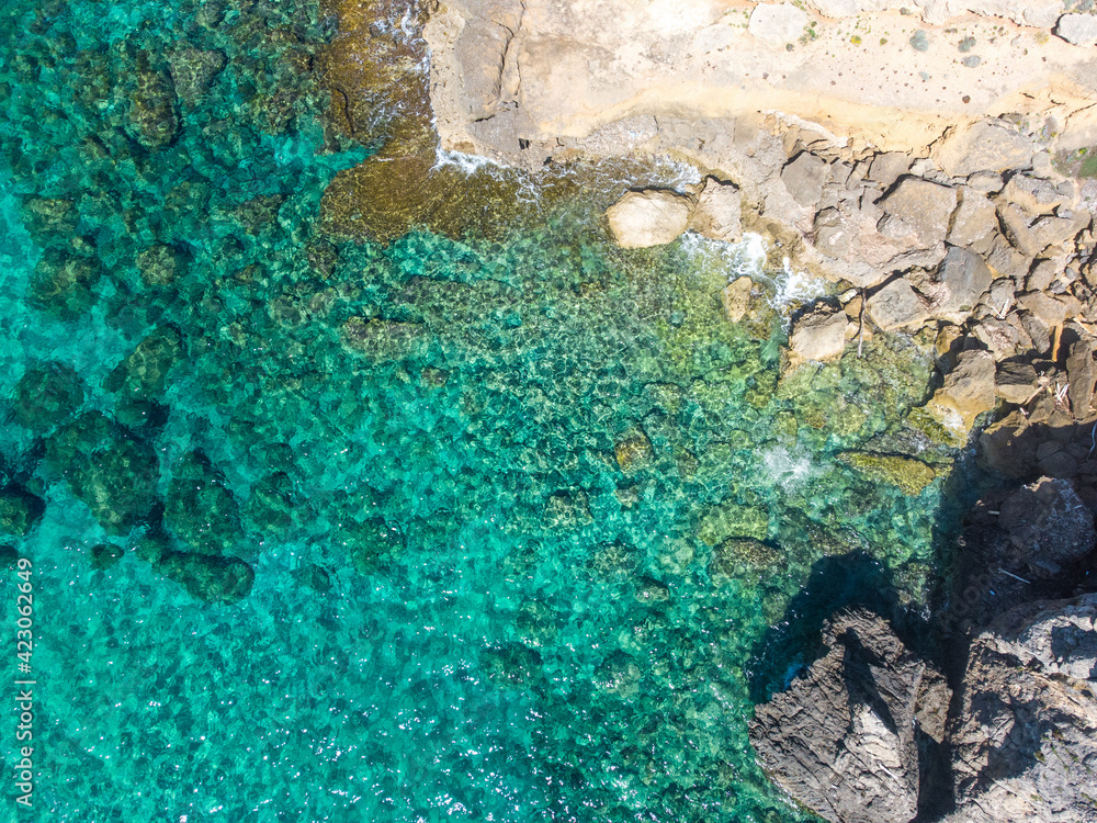 Turquoise water and rocks in Alghero shoreline