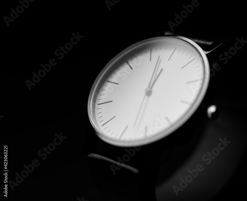 white modern analog wristwatch on a black background