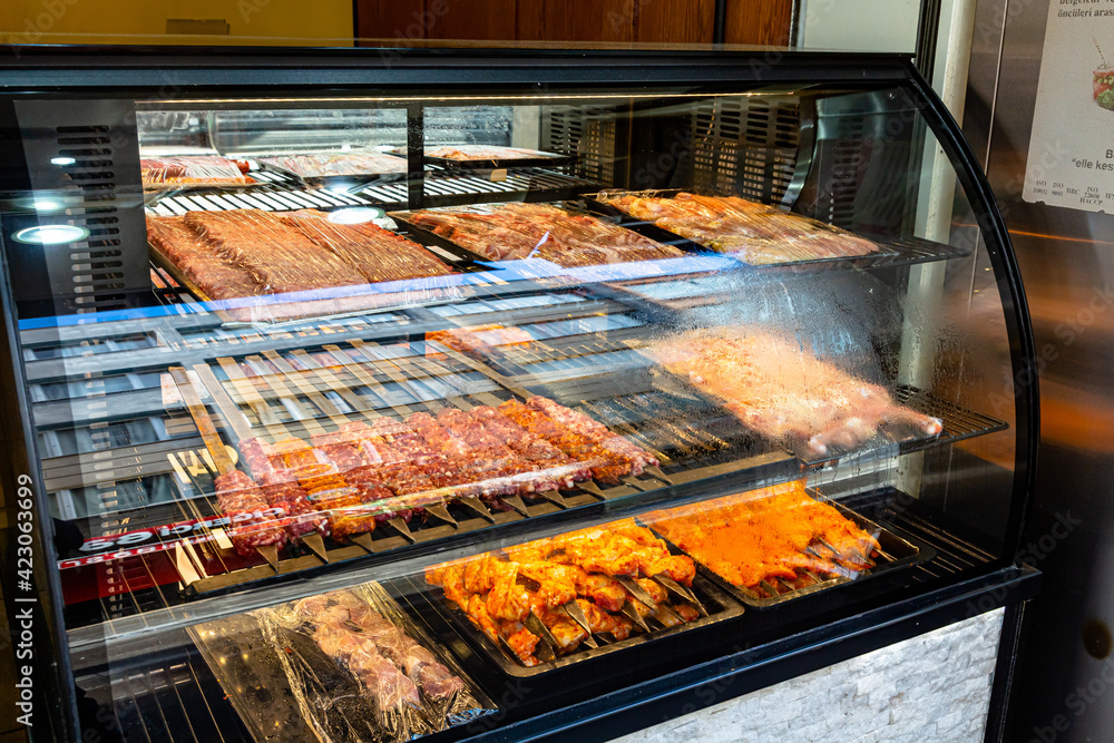 Different types of shish kebab and kebab are on the glass display in the restaurant. They will be prepared for you on the spot.