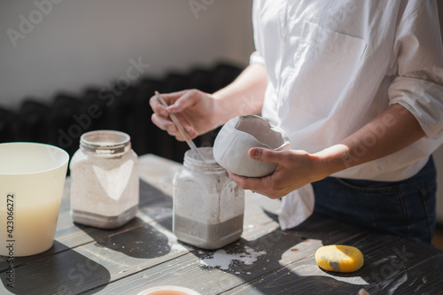 Production process of pottery. Application of glaze brush on ceramic ware.
