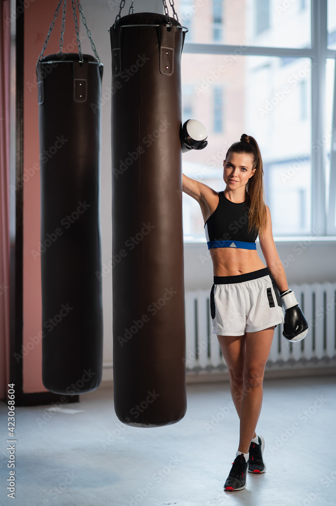 Female fighter trains her punches, training day in the boxing gym, the girl trains a series of punches