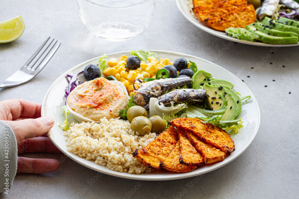 Top view of plates with delicious fresh apple and lime slices near sweet potato wedges and olives with hummus on table Top view of plates with delicious fresh apple and lime slices near sweet potato wedges and olives with hummus on table