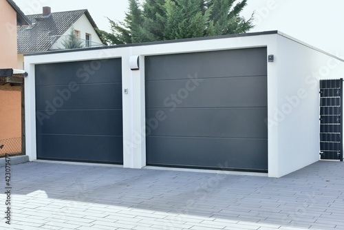 Moderne Beton-Garage mit Automatik-Tor in der Wohngebäude-Zufahrt