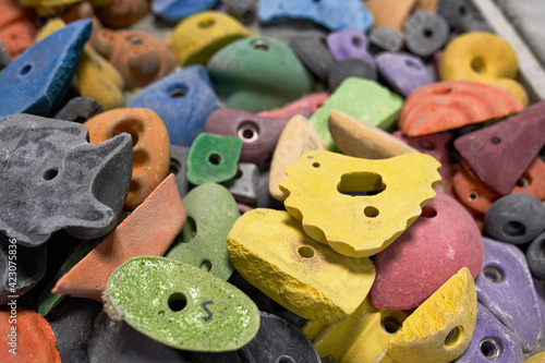 High angle of various types and colors of climbing holds in modern gym photo