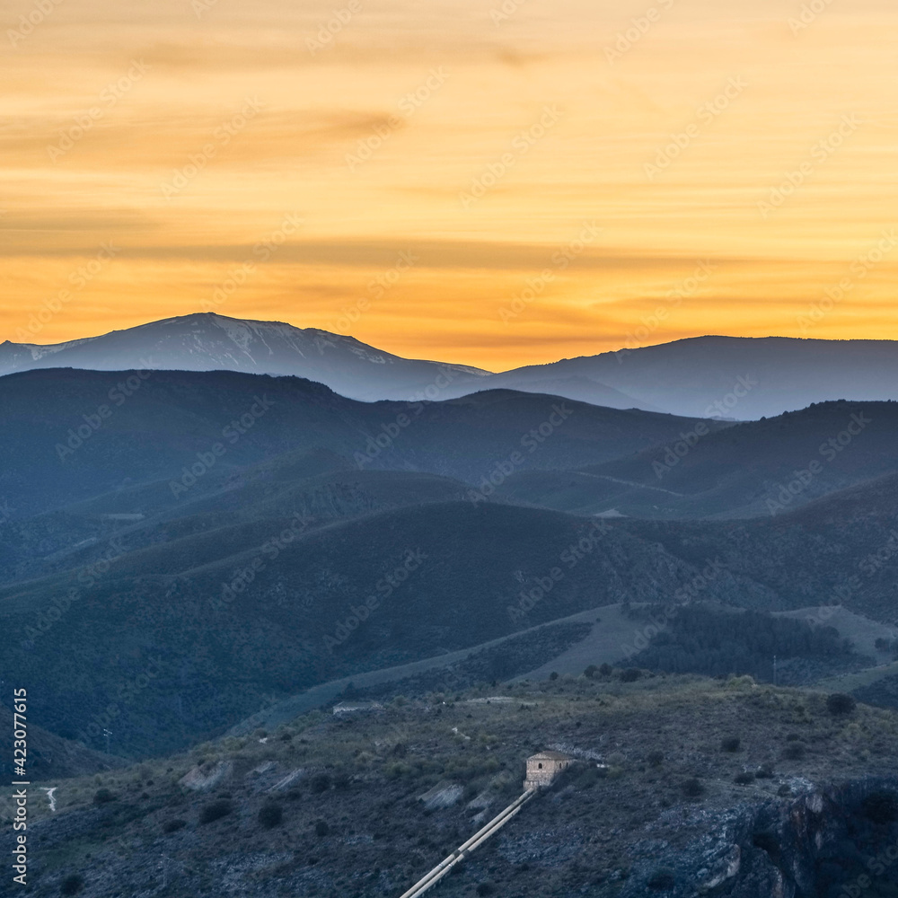 Naklejka premium cielo amarillo sobre las montañas, niebla entre las montañas, vista panorámica de las colinas al atardecer