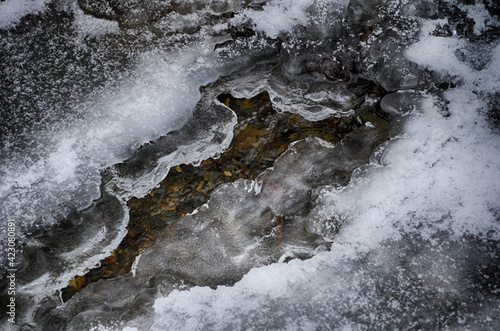 Ice-free little river in winter. Stream of river water. The snow cover. Winter abstract background. © maria