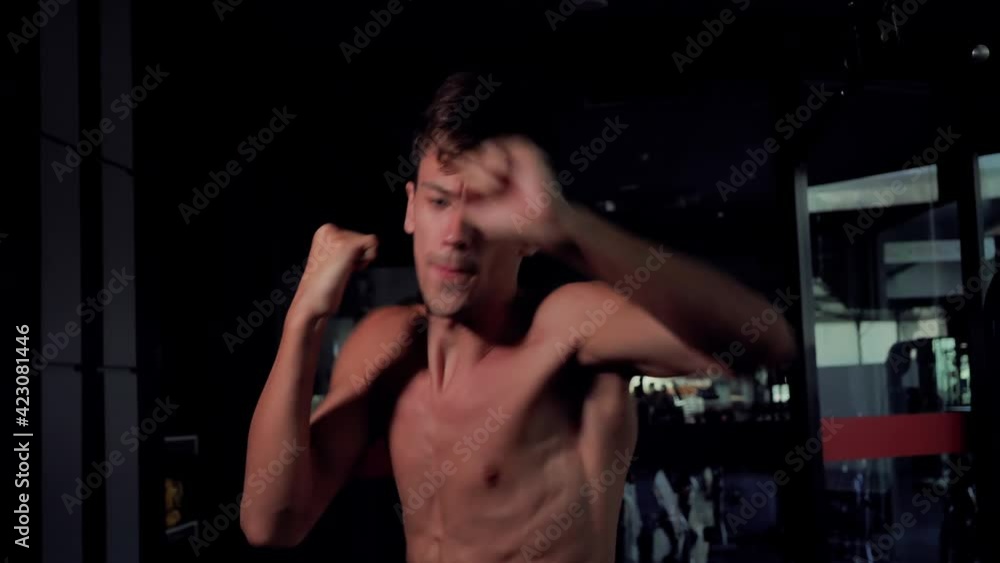 Front view slow motion Man boxing punshing looking at camera, Kickboxing training day in a gym