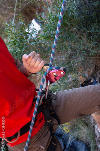 man climbing a mountain with rope