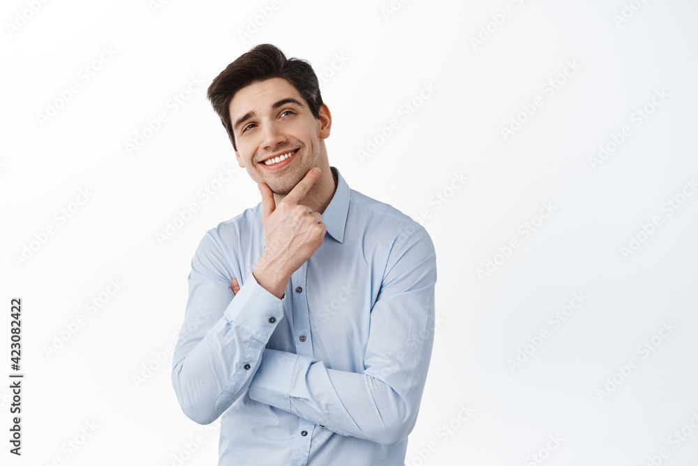 Thoughtful successful businessman, ceo manager look aside and thinking, imaging something with pleased face, smiling, standing over white background Thoughtful successful businessman, ceo manager look aside and thinking, imaging something with pleased face, smiling, standing over white background