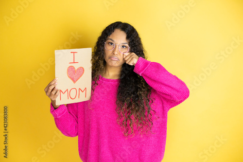 Beautiful woman celebrating mothers day holding poster love mom message depressed and worry for distress, crying angry and afraid. Sad expression.