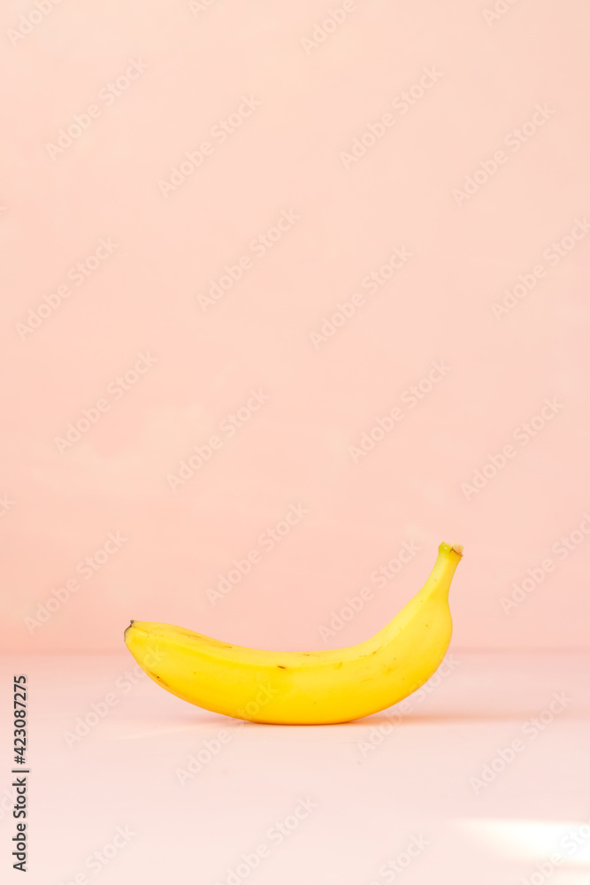 yellow bananas lie on a pink background, a bunch of bananas in the sunlight. Vegetables fruits, text space, free space, vegan, vegan food, vegetarian, apples, strawberries