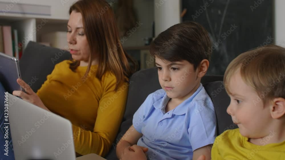 mother using laptop computer with her kids at home mother using laptop computer with her kids at home