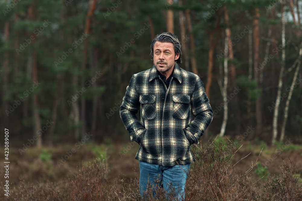 Man with stubble beard in a checkered coat in a rainy heathland. Man with stubble beard in a checkered coat in a rainy heathland.