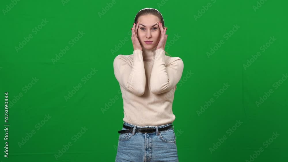 Young exhausted woman rubbing temples at chromakey background. Portrait of ill Caucasian lady having headache on green screen. Migraine and medical problems. Young exhausted woman rubbing temples at chromakey background. Portrait of ill Caucasian lady having headache on green screen. Migraine and medical problems.