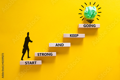 Start strong and keep going symbol. Concept words 'Start strong and keep going' on wooden blocks on a beautiful yellow background. Businessman icon. Business, motivational and start strong concept.