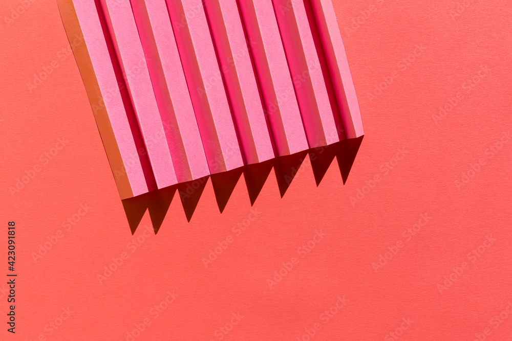 Abstract pink colored paper texture. Folded paper with harsh sun shadows, geometric shapes and lines. Minimalist background. Flat lay. Copy space. Abstract pink colored paper texture. Folded paper with harsh sun shadows, geometric shapes and lines. Minimalist background. Flat lay. Copy space.