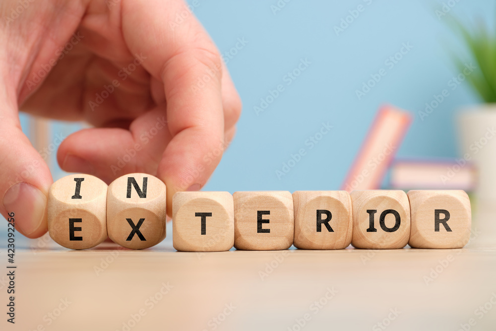 Choosing concept antonyms interior and exterior on wooden cubes Stock