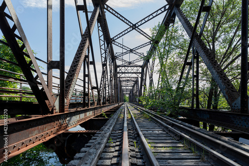 point de vue d'un pont de train avec gros plan sur les rails en été lors d'une journée ensoleillée © Veronique