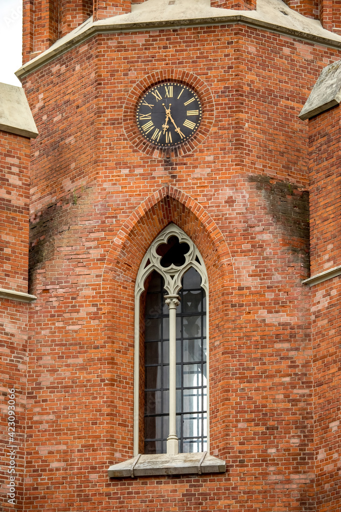 Ornate window and clock on the wall of  Church of St Matthew the Apostle, Rokiskis, Lithuania