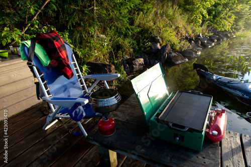 Fotografie réchaud portatif sur le quai en bois au bord de l'eau lors d'un lever de soleil
