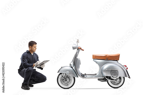 Bike repair mechanic kneeling in front of a vintage scooter