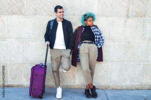 travel couple with luggage on street