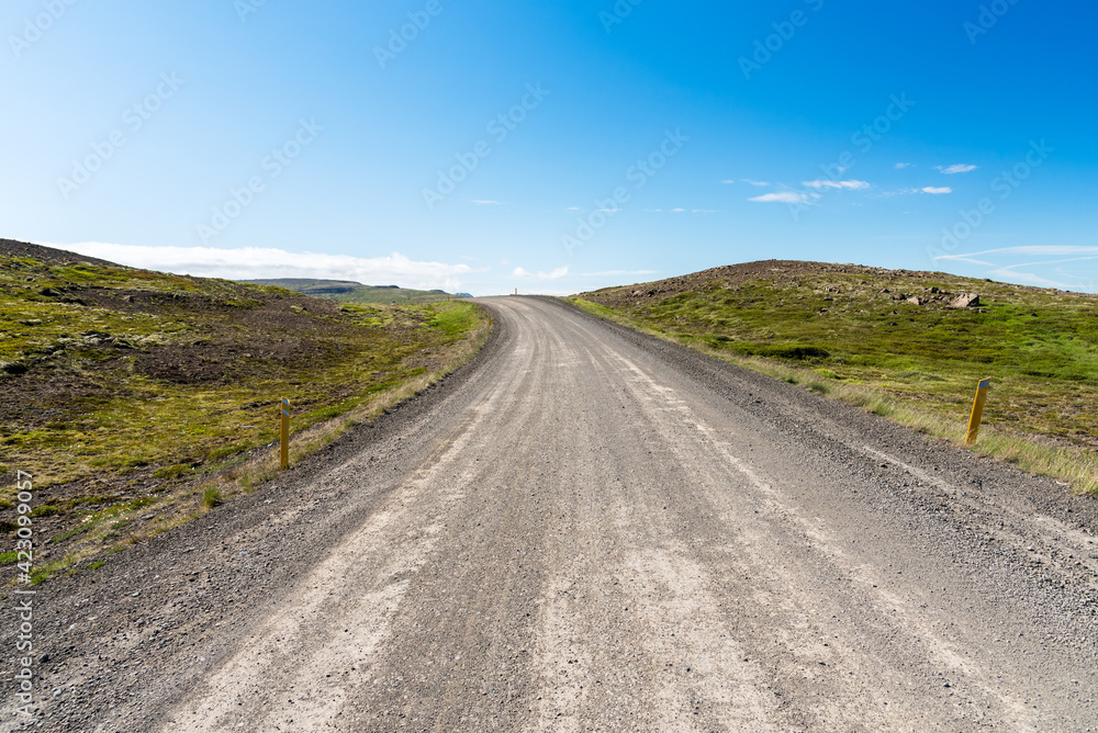 Curve along a remote gravel road under blues sky in Iceland