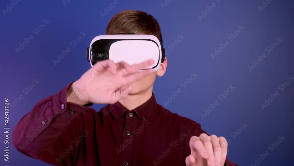 Child in virtual reality helmet gestures controls. Child in virtual reality helmet gestures controls.