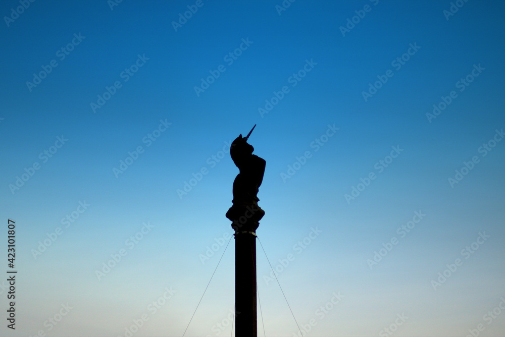 Unicorn silhouette on Glasgow cross, Scotland with blue sky