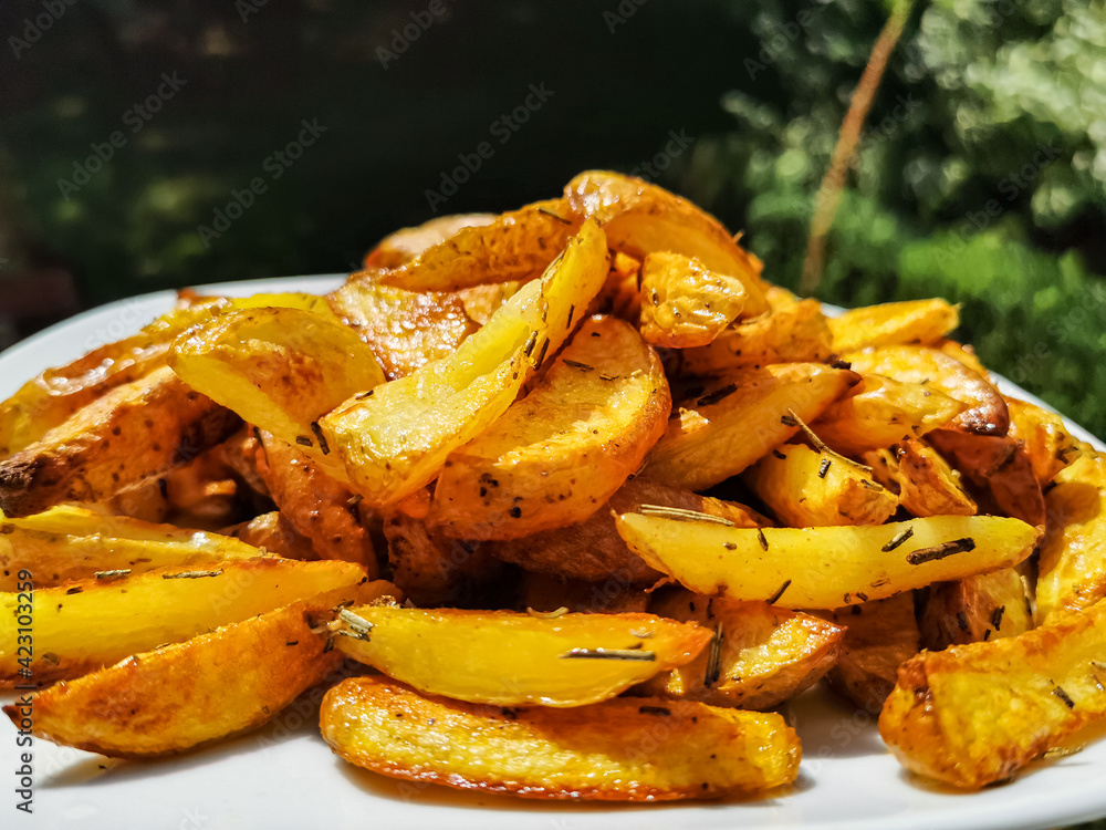 homemade baked Potatoe chips on a white plate in the garden homemade baked Potatoe chips on a white plate in the garden