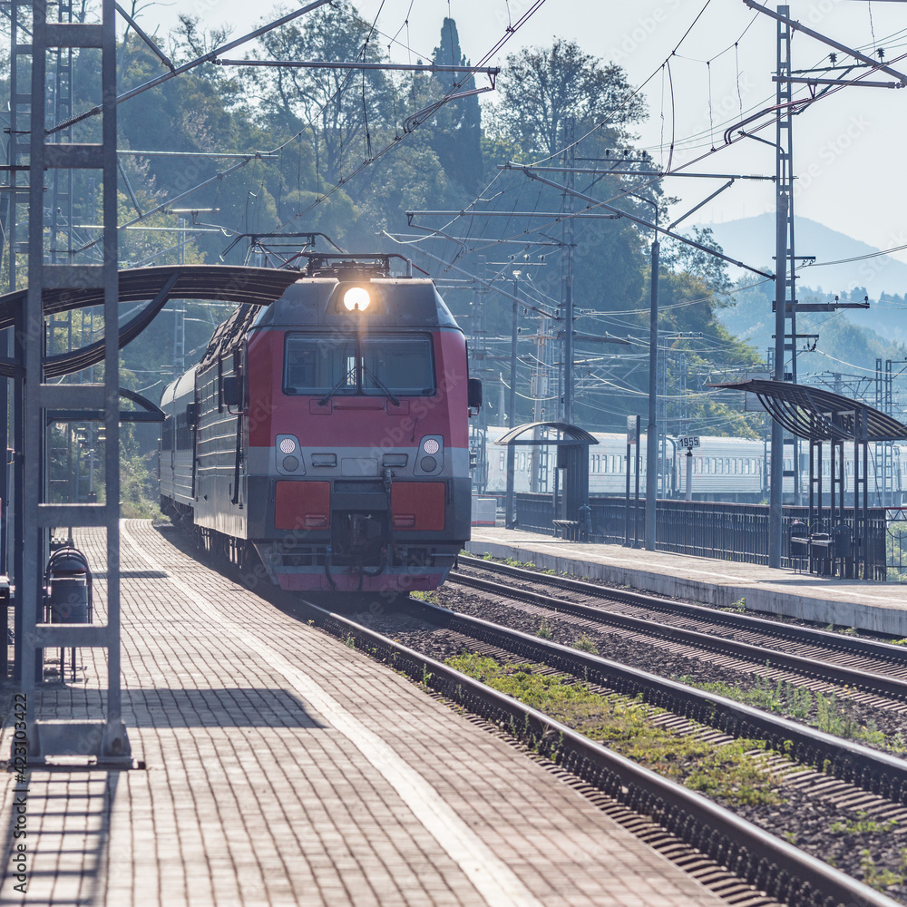 Passenger train moves along Black sea coast. Sochi.