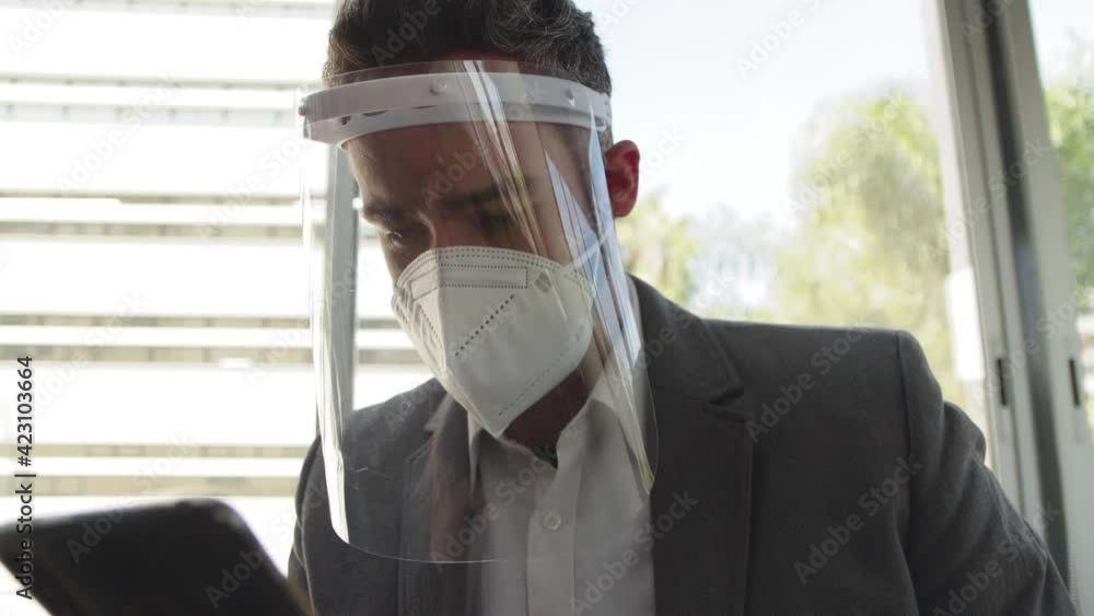 Hombre utiliza mascarilla y careta en oficina prevencio pandemia