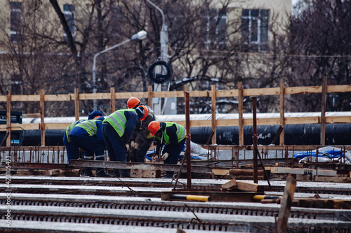 Workers in protective helmets are repairing bridge in Voronezh