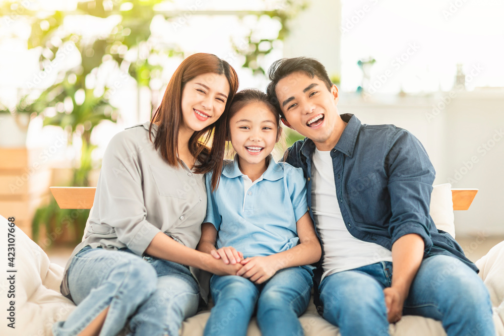  Happy family smiling and hugging on the couch at home