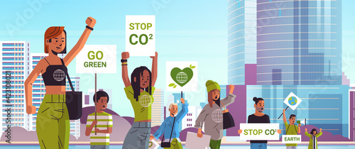 environmental activists holding posters go green save planet strike concept protesters campaigning to protect earth demonstrating against global warming portrait cityscape background horizontal