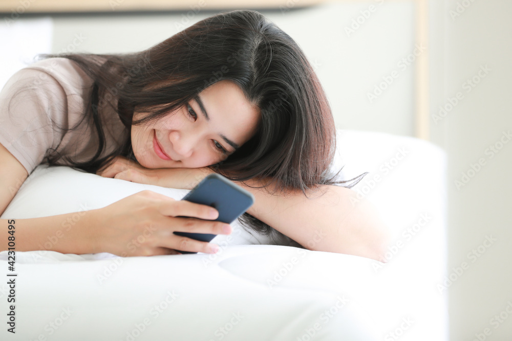 Woman using telephone on bed in bedroom. Woman using telephone on bed in bedroom.