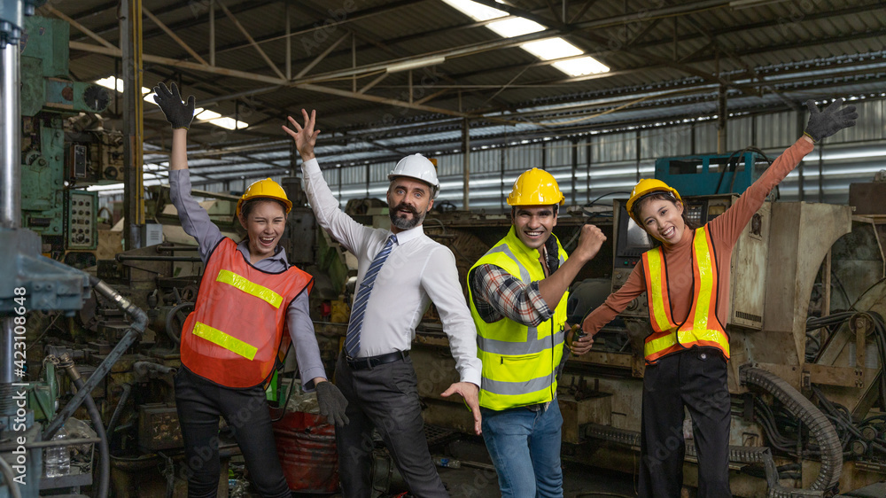 Group of factory workers or engineers with safety gears and hardhat express a great happiness after big business success or achievements Group of factory workers or engineers with safety gears and hardhat express a great happiness after big business success or achievements