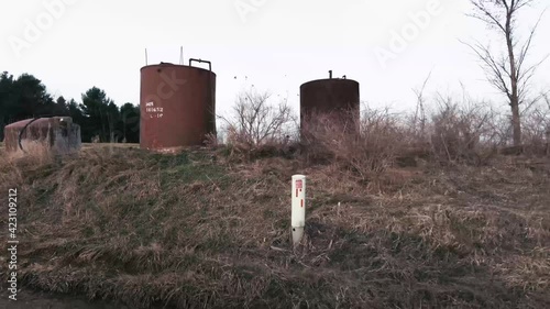 Slow motion driving past an Oil collection tank on a farm. photo