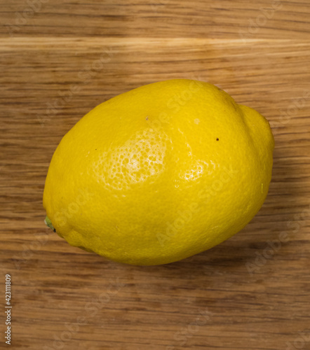 A fresh lemon on a wooden table - food photography