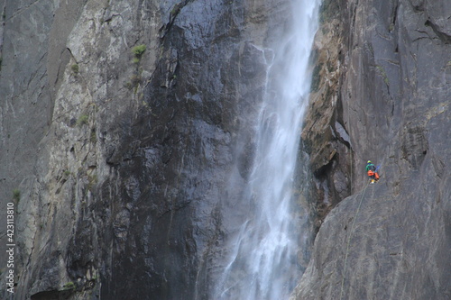 rock climber by a waterfall on the cliff