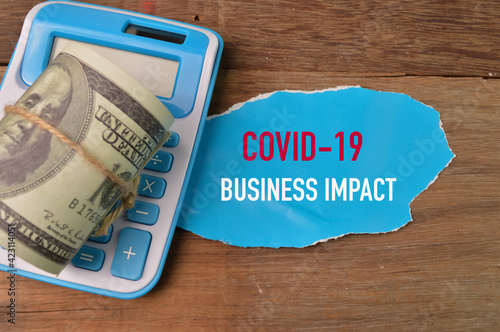 Wallpaper Mural Money banknote, calculator and torn paper written with COVID-19 BUSINESS IMPACT. Torontodigital.ca