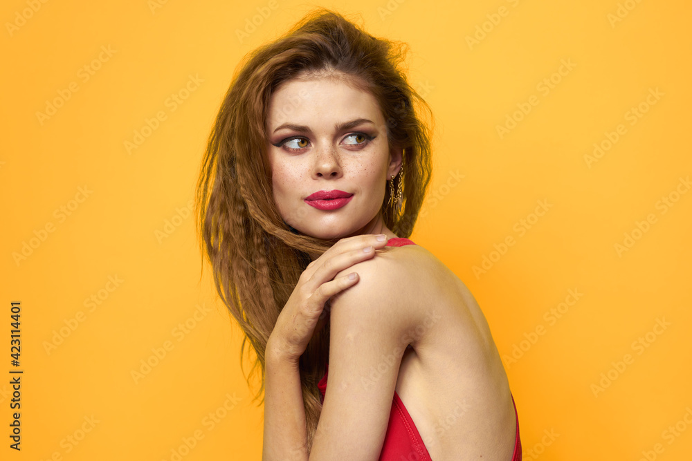 Pretty woman wavy hair red tank top fashion lifestyle cosmetics yellow background Pretty woman wavy hair red tank top fashion lifestyle cosmetics yellow background