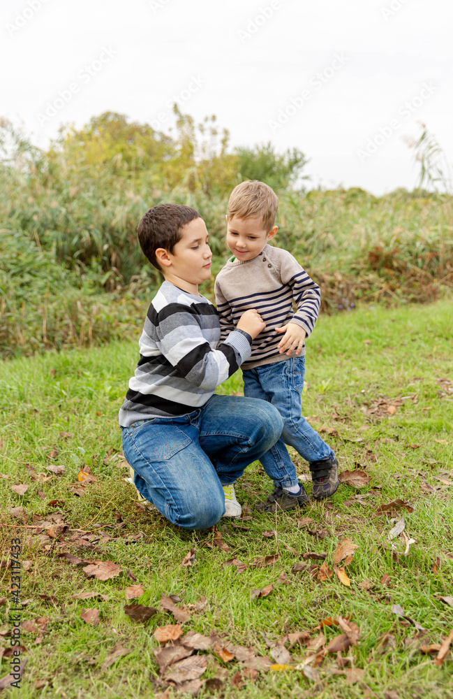Fototapeta premium Boys are fighting. Children fight in the park. Sibling bad relationships, two children conflict and rivalry concept. A feud between children. Communication problems. Children are having a disagreement